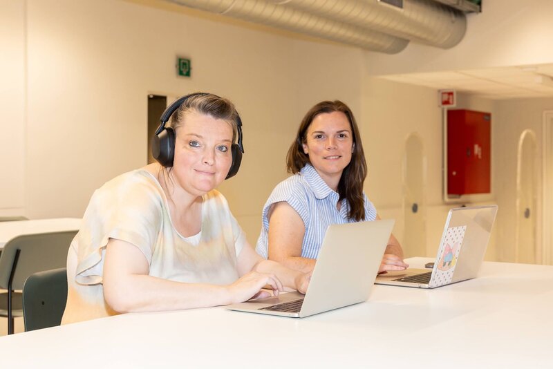 Twee volwassen studenten aan het werk met de laptop in het leercentrum